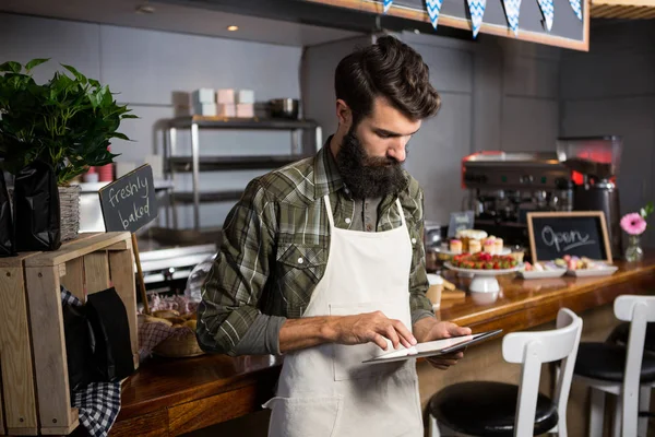 Male staff using digital tablet at counter — Stock Photo, Image