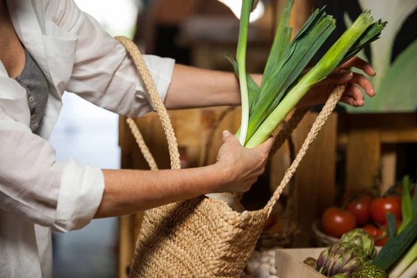 Mulher comprando vegetais folhosos na seção orgânica — Fotografia de Stock