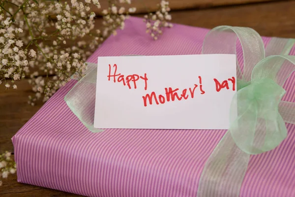 Gelukkig moeders dag kaart op de doos van de gift met bloemen — Stockfoto