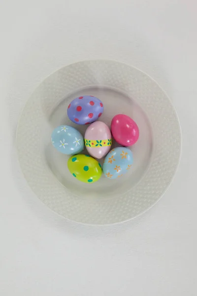 Розфарбовані великодні яйця, розташовані в тарілці — стокове фото