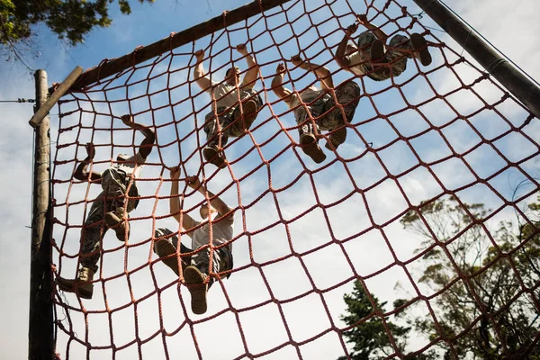 Military soldiers climbing rope during obstacle course — Stock Photo, Image