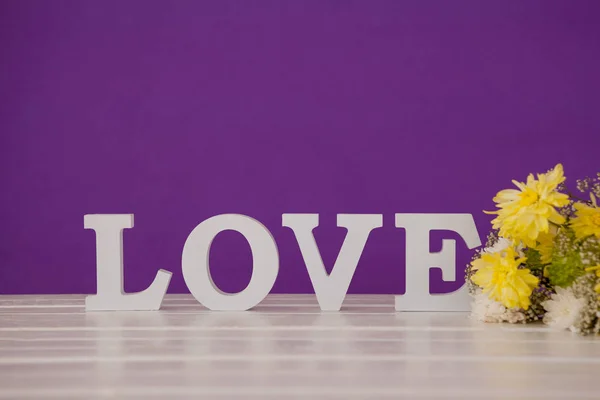 Aşk masaya şekillendirme alfabe ile sarı çiçek — Stok fotoğraf