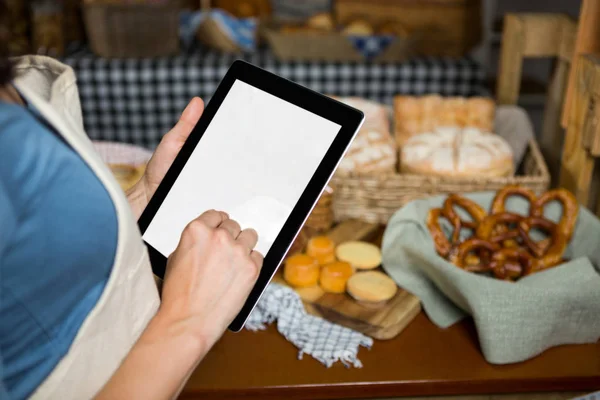 A meio da seção de pessoal usando tablet digital no balcão da padaria — Fotografia de Stock