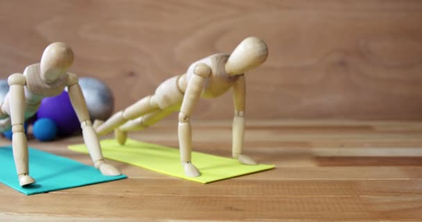 Wooden figurine exercising on exercise mat — Stock Video