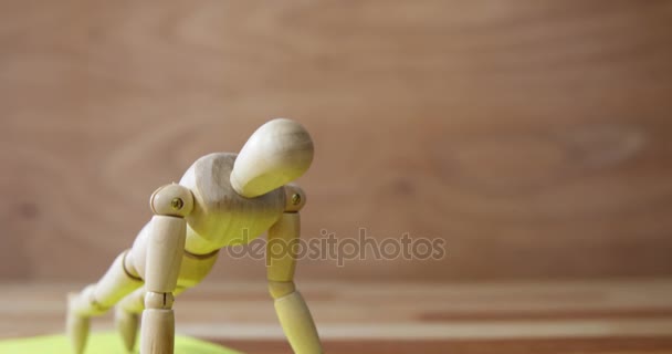 Wooden figurine exercising on exercise mat — Stock Video