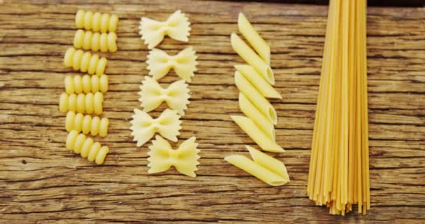 Различные макароны на деревянном столе — стоковое видео