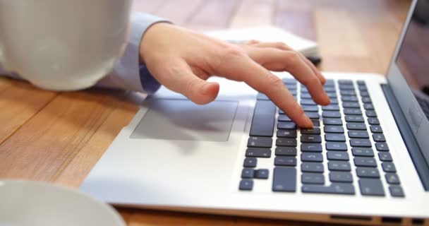 Frau arbeitet am Laptop, während sie am Schreibtisch Kaffee trinkt — Stockvideo