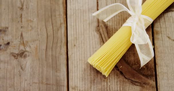 Кучка сырых спагетти, связанных белой лентой — стоковое видео