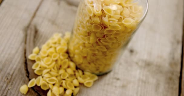 Pasta de conchiglion en tarro sobre mesa de madera — Vídeos de Stock