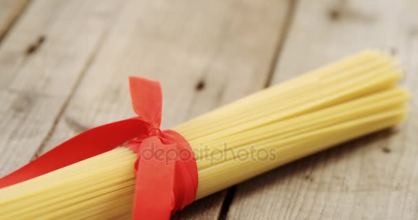 Bos van ruwe spaghetti vastgebonden met rood lint — Stockvideo