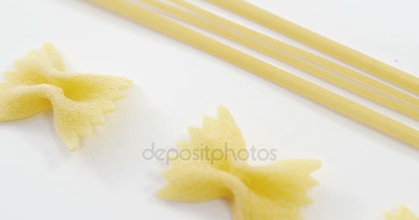 Arco amarrar macarrão e espaguete no fundo branco — Vídeo de Stock
