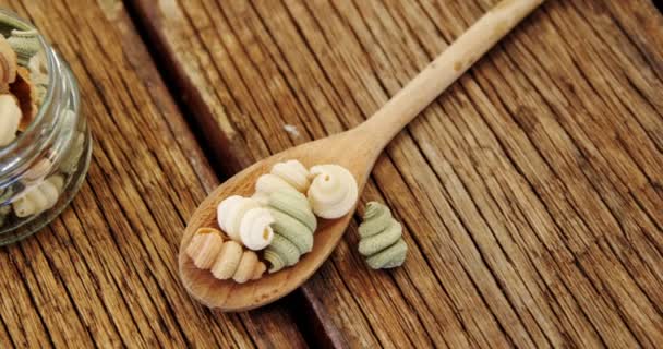 Half shell shaped pasta in jar on  wooden background — Stock Video