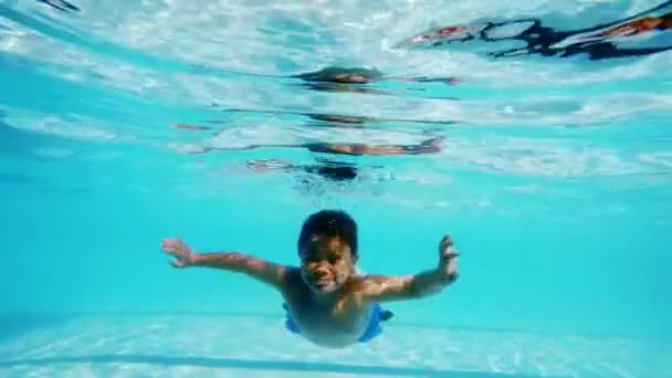 Niño nadando bajo el agua en la piscina — Vídeo de stock