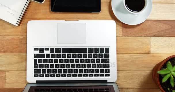 Hand of businesswoman using mobile phone at desk with coffee, laptop and digital tablet on table — Stock Video