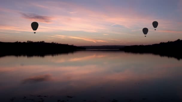 Balões de ar quente voando sobre o lago durante o crepúsculo — Vídeo de Stock