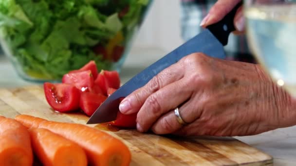 Mãos de mulher sênior que prepara a salada vegetal — Vídeo de Stock