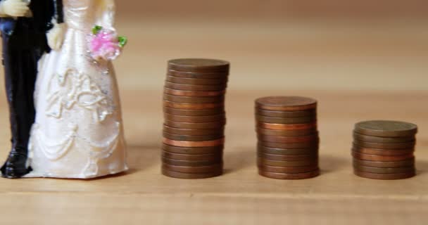 Miniaturní svatební pár stojící vedle zásobníku mincí — Stock video