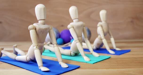 Figurine en bois s'exerçant sur tapis d'exercice — Video
