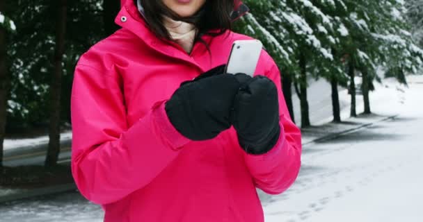 Femme souriante en vêtements chauds à l'aide d'un téléphone mobile — Video