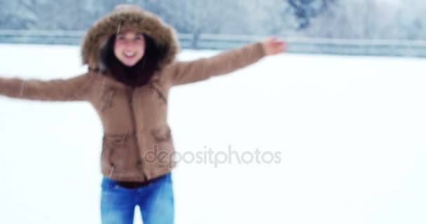 Donna sorridente in giacca di pelliccia godendo la nevicata — Video Stock