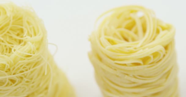 Rulle av tagliatelle pasta på vit bakgrund — Stockvideo