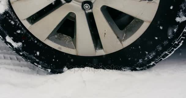 Neumático de coche en movimiento sobre nieve durante las nevadas — Vídeos de Stock