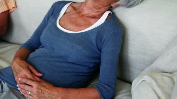 Старшая женщина спит на диване в гостиной — стоковое видео