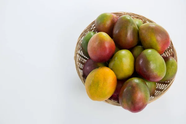 Sobrecarga de mangos rojos en canasta de mimbre — Foto de Stock