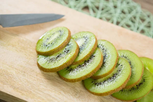 Slices of kiwi on chopping board — Stock Photo, Image