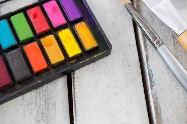 Renkli paleti ve ahşap yüzeyine boya fırçaları — Stok fotoğraf