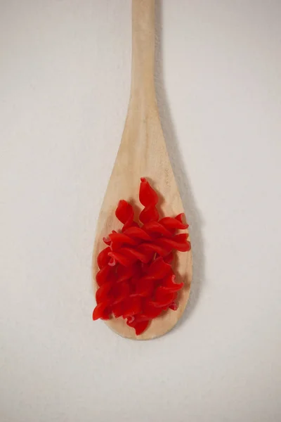 Красный ротини в деревянной ложке — стоковое фото