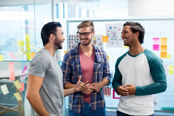 Equipo creativo de negocios discutiendo contra la pizarra blanca y las notas adhesivas — Foto de Stock