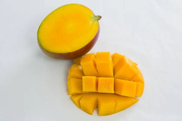 Половинчатый и нарезанный манго на белом фоне — стоковое фото