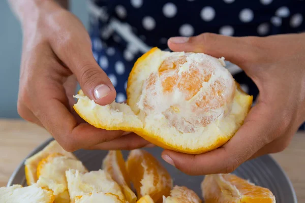 Woman peeling orange — Stock Photo, Image