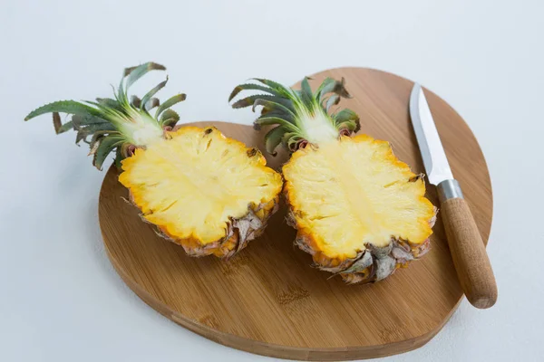 Крупный план двух ананасов на доске для рубки — стоковое фото