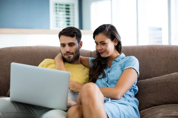 Par som använder laptop i vardagsrummet — Stockfoto