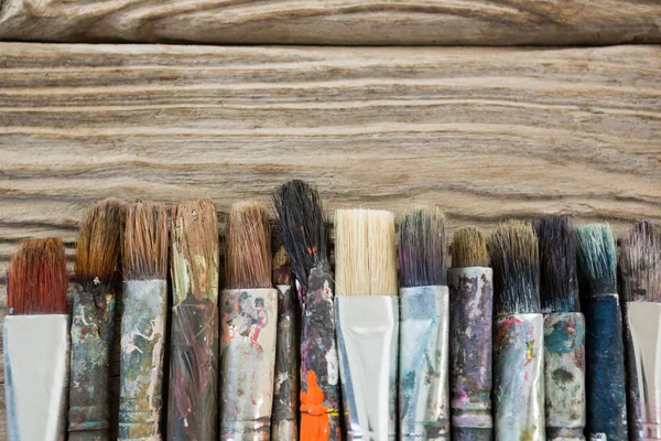 Various dirty paintbrush arranged in a row — Stock Photo, Image