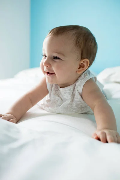 Ładna dziewczynka uśmiechający się na łóżku — Zdjęcie stockowe