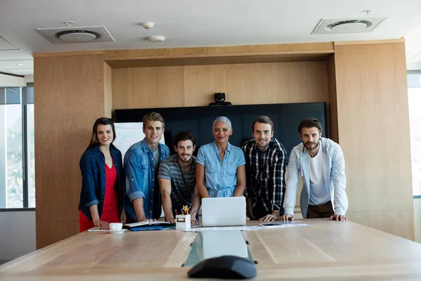 Equipe de negócios criativa em pé na sala de conferências com laptop — Fotografia de Stock