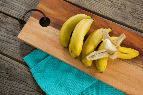 Cobertura de bananas frescas em tábua de cortar — Fotografia de Stock