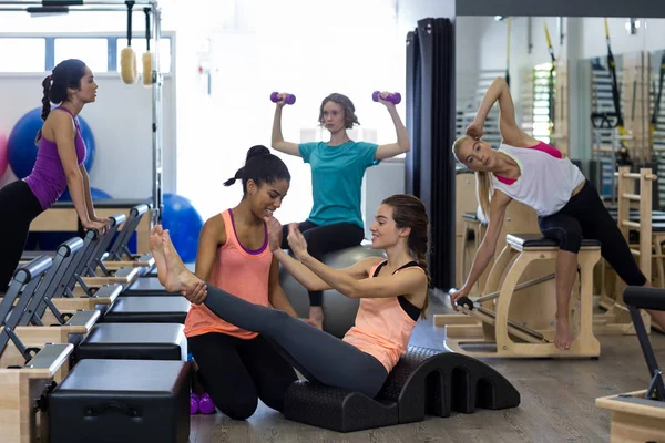 Entrenador femenino que ayuda a la mujer con el ejercicio de estiramiento en el barril de arco —  Fotos de Stock