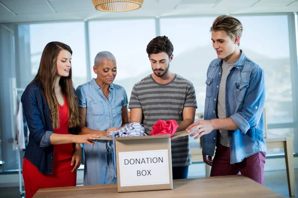 Team creativo di business ordinare i vestiti in scatola di donazione — Foto Stock