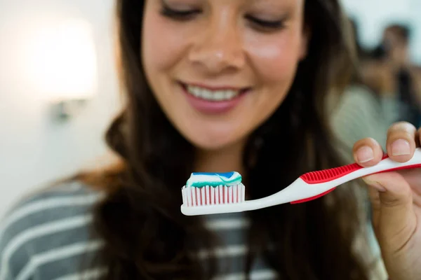 Close-up of happy young woman holding toothbrush with toothpaste — Stock Photo, Image