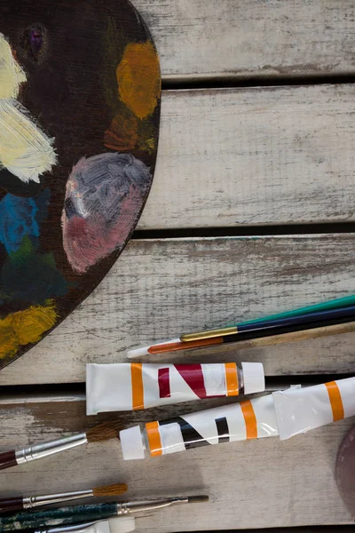 Pinturas de acuarela, paleta y pinceles sobre superficie de madera — Foto de Stock