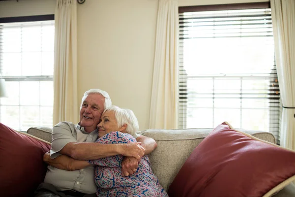 Lyckliga senior paret omfamnar varandra i vardagsrum — Stockfoto
