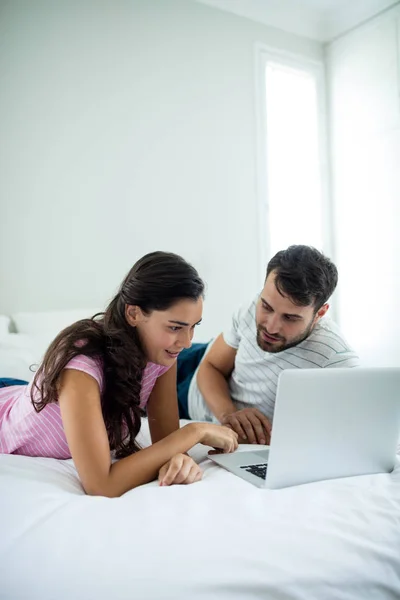 Paar benutzt Laptop im Schlafzimmer — Stockfoto