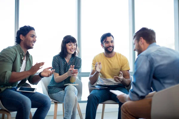 Creative business team applauding for their colleague in office — Stock Photo, Image