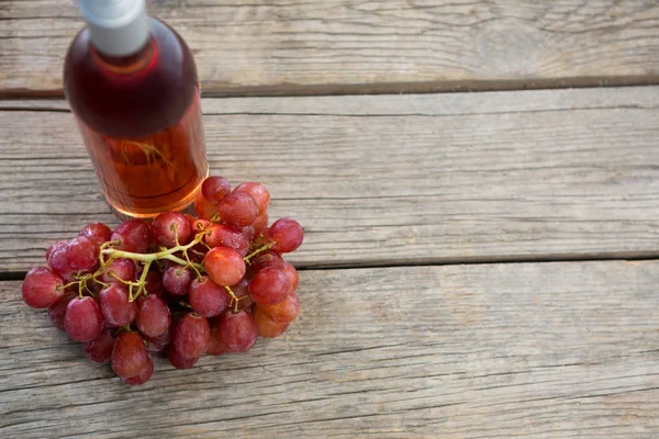 Overhead de cacho vermelho de uvas com garrafa de vinho tinto — Fotografia de Stock