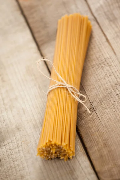 Pacchetto di spaghetti crudi legati con nastro bianco — Foto Stock