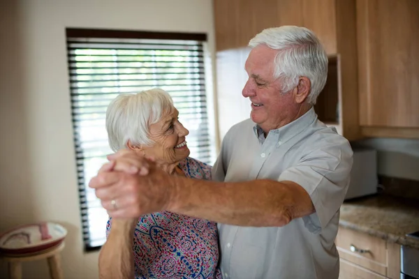 Äldre par dansar tillsammans i köket — Stockfoto